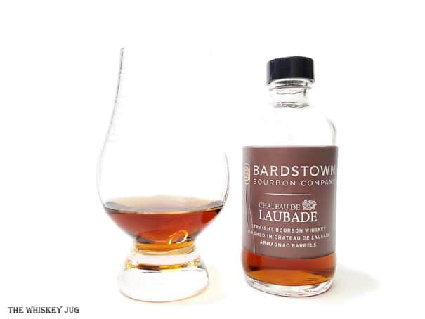 White background tasting shot with the Bardstown Bourbon Laubade Armagnac Finish bottle and a glass of whiskey next to it.