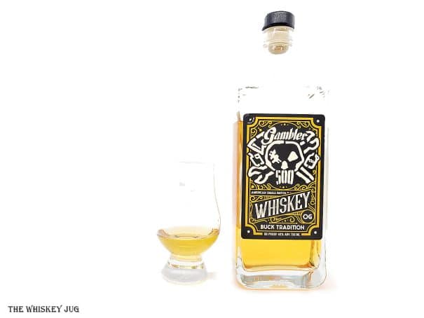 White background tasting shot with the Gambler 500 Whiskey bottle and a glass of whiskey next to it.