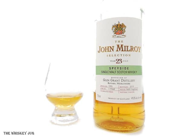 White background tasting shot with the 1995 John Milroy Glen Grant 23 Years bottle and a glass of whiskey next to it.