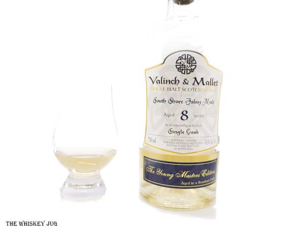 White background tasting shot with the Valinch and Mallet South Shore Islay Malt 8 Years bottle and a glass of whiskey next to it.