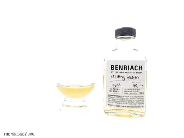 White background tasting shot with the Benriach Malting Season sample bottle and a glass of whiskey next to it.