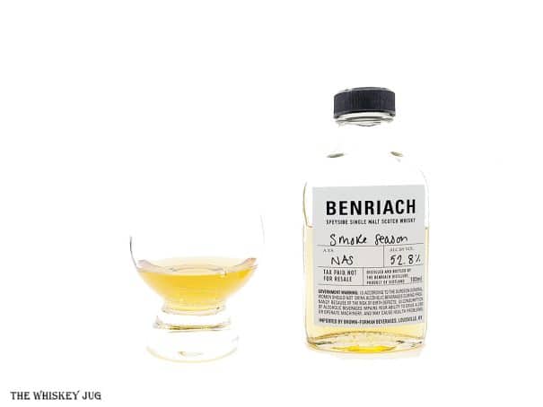White background tasting shot with the Benriach Smoke Season bottle and a glass of whiskey next to it.