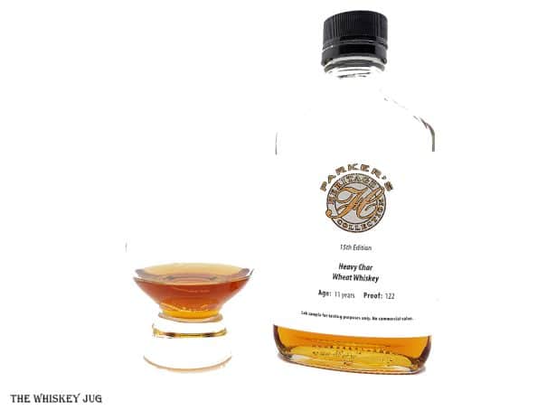 White background tasting shot with the Parker's Heritage 15th Edition sample bottle and a glass of whiskey next to it.