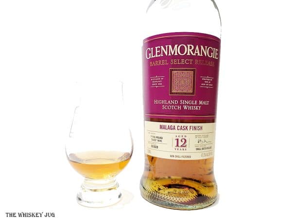 White background tasting shot with the Glenmorangie Malaga Cask Finish 12 Years bottle and a glass of whiskey next to it.
