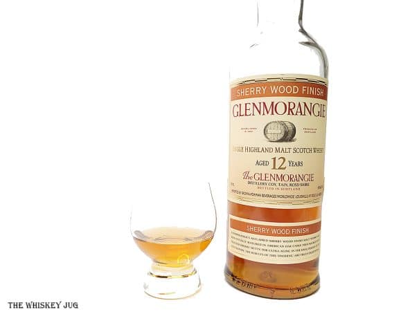 White background tasting shot with the Glenmorangie Sherry Wood 12 Years bottle and a glass of whiskey next to it.