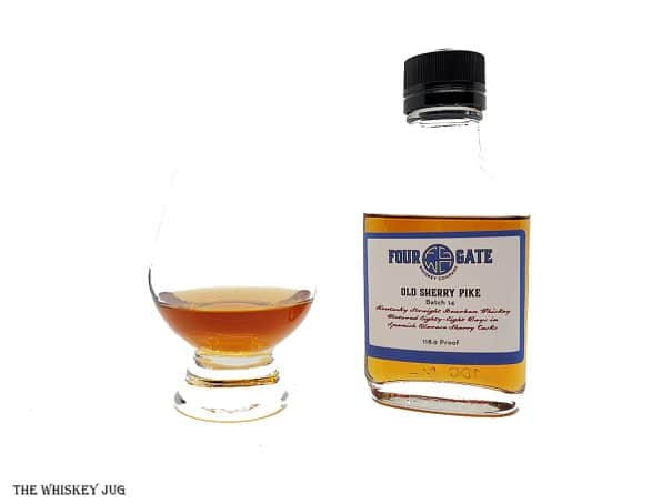 White background tasting shot with the Four Gate Old Sherry Pike sample bottle and a glass of whiskey next to it.