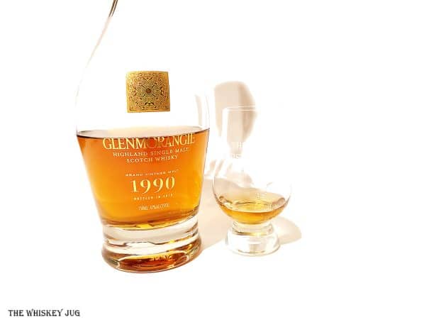 White background tasting shot with the Glenmorangie Grand Vintage Malt 1990 bottle and a glass of whiskey next to it.