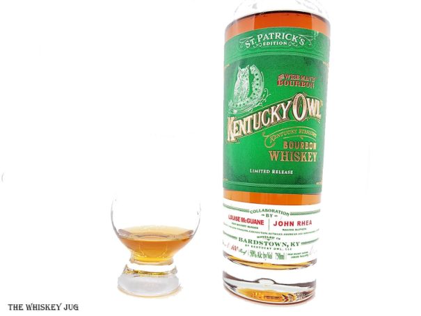 White background tasting shot with the Kentucky Owl St. Patrick’s Limited Edition bottle and a glass of whiskey next to it.