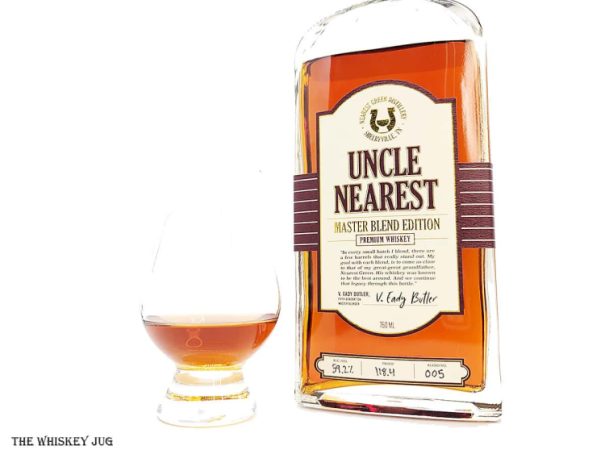 White background tasting shot with the Uncle Nearest Master Blend Edition bottle and a glass of whiskey next to it.