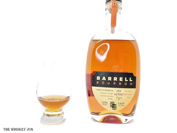 White background tasting shot with the Barrell Bourbon Batch 032 bottle and a glass of whiskey next to it.