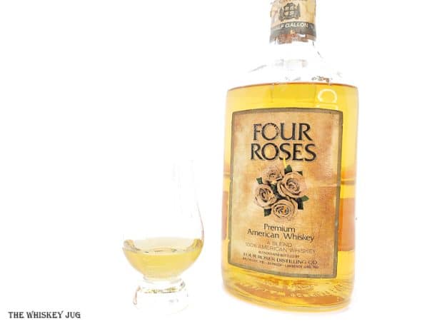 White background tasting shot with the Four Roses Premium American Whiskey (blended) bottle and a glass of whiskey next to it.