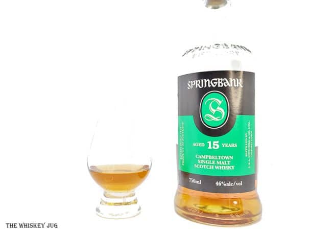 White background tasting shot with the Springbank 15 Years bottle and a glass of whiskey next to it.