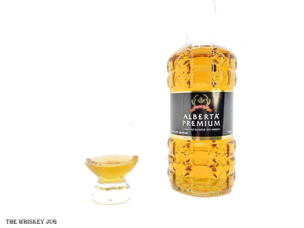 White background tasting shot with the Alberta Premium Blended Rye Whisky bottle and a glass of whiskey next to it.