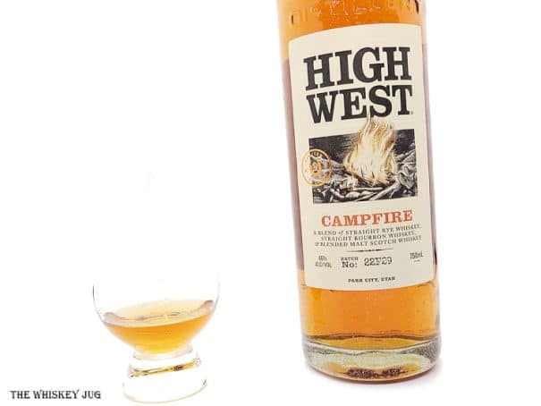 White background tasting shot with the High West Campfire Batch 22F29 bottle and a glass of whiskey next to it.